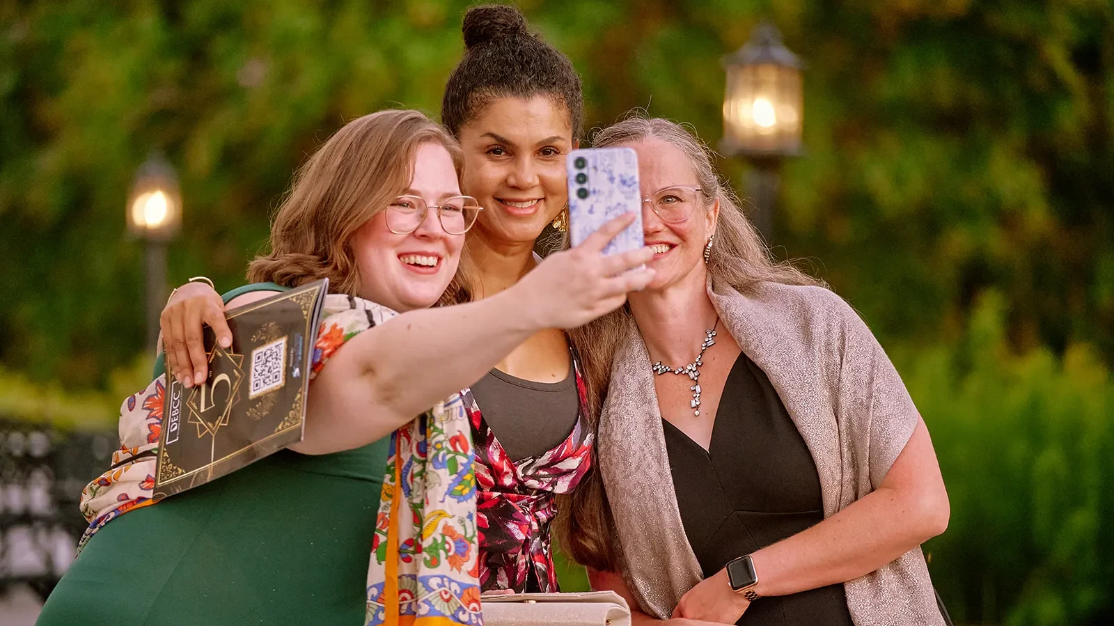 A group of attendees taking a picture on their cell phone.