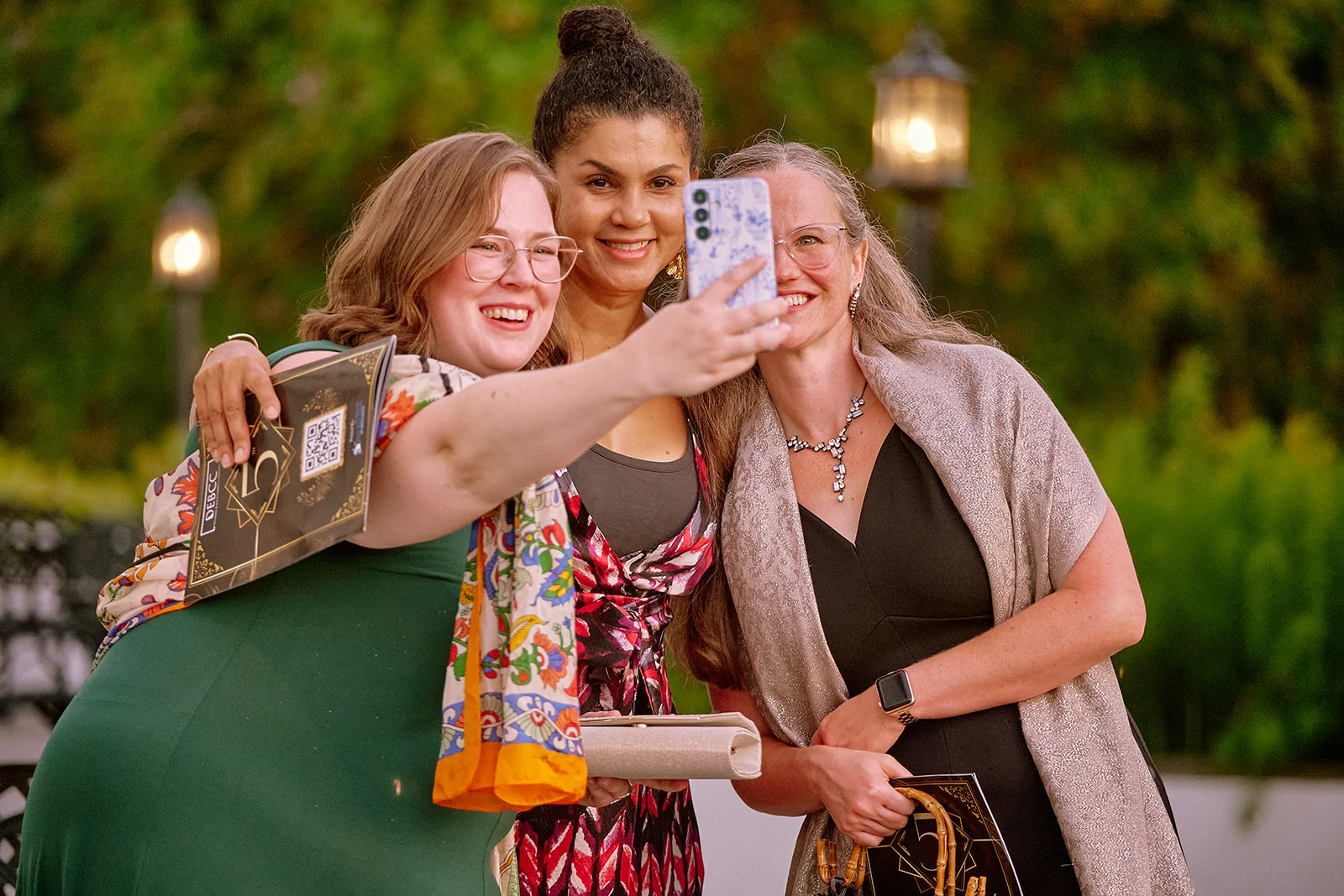 A group of attendees taking a picture on their cell phone.